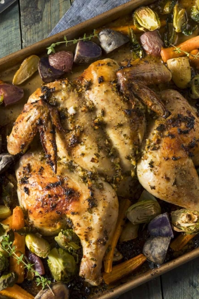 rimmed baking sheet with roast chicken and vegetables