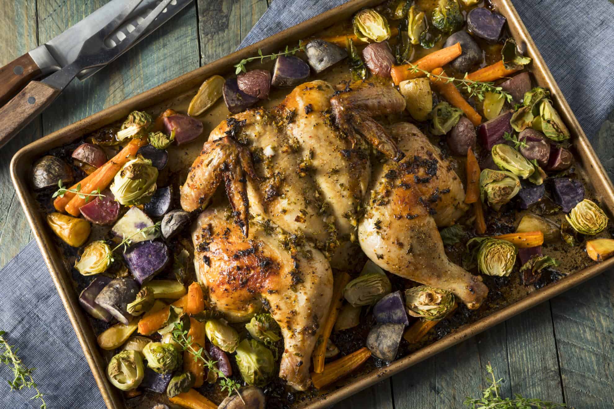 rimmed baking sheet with roast chicken and vegetables