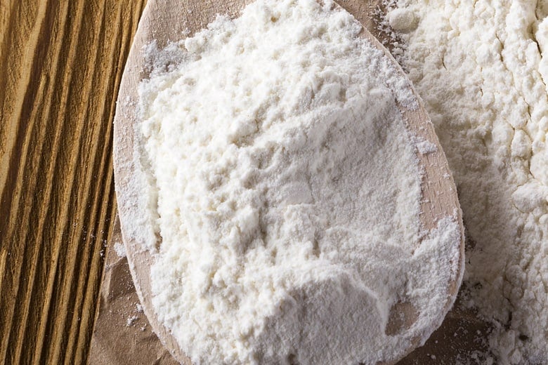 self rising flour in a wood spoon