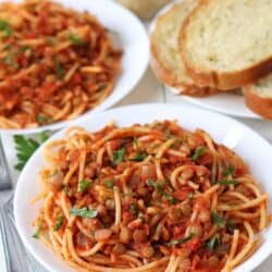 lentil bolognese over pasta on a plate