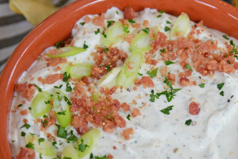 close up of potato chip dip with bacon and green onions 