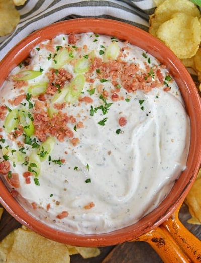 bowl of bacon ranch dip with scallions and potato chips