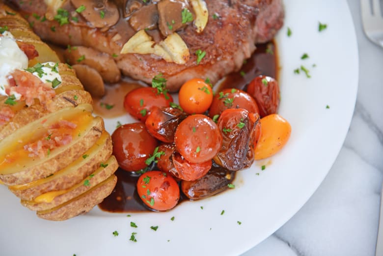 stewed tomatoes served with potatoes and steak 