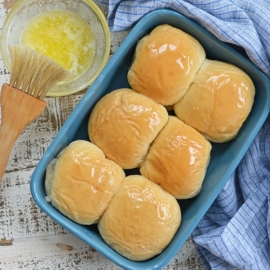 buttered dinner rolls in a blue baking dish