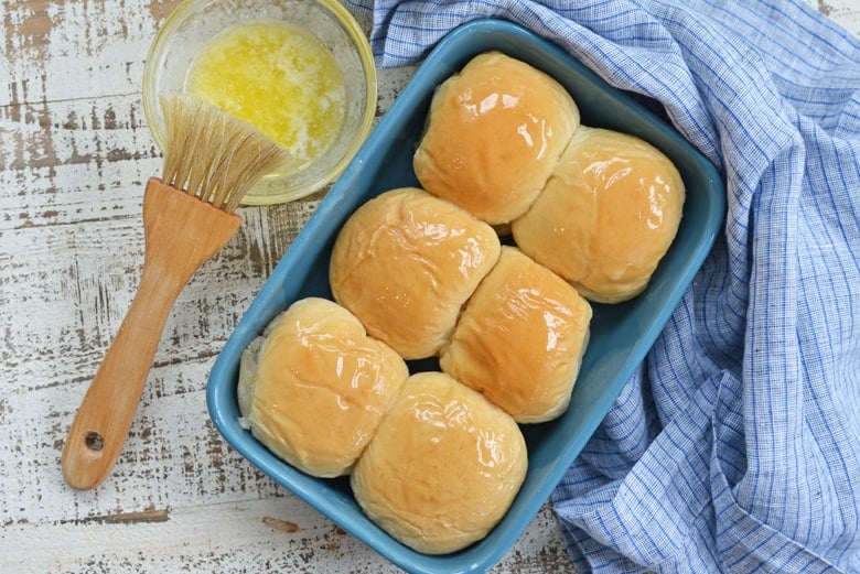 buttered dinner rolls in a blue baking dish