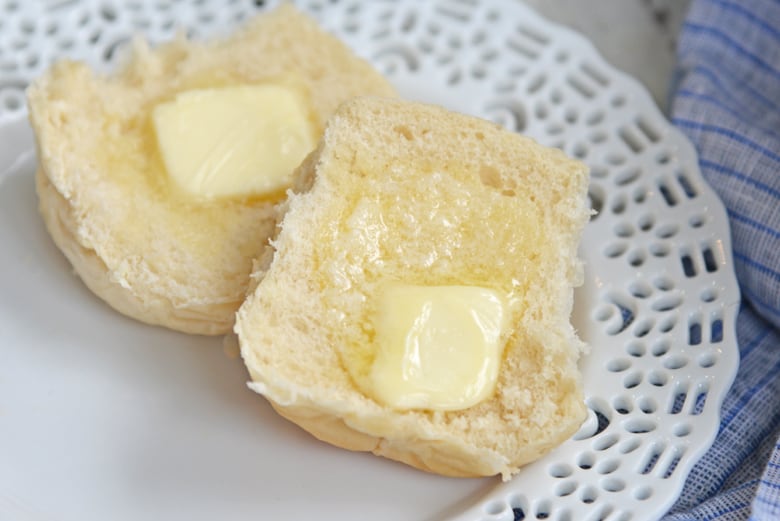 quick rolls with melted butter on a white bread plate 