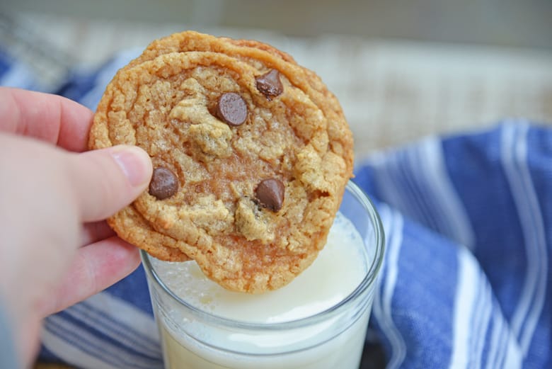 flourless peanut butter cookie dipping into a glass of milk 