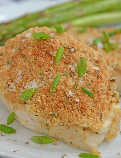 garlic parmesan chicken on a white plate with asparagus