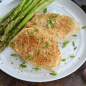 garlic parmesan chicken on a white plate with asparagus
