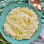 blue bowl of instant pot mashed potatoes with butter and scallions