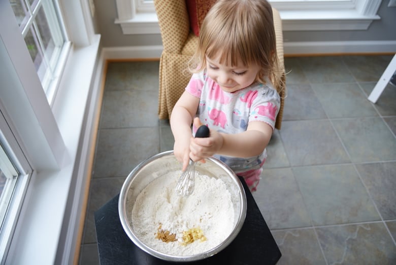 little girl mixing bread dough 