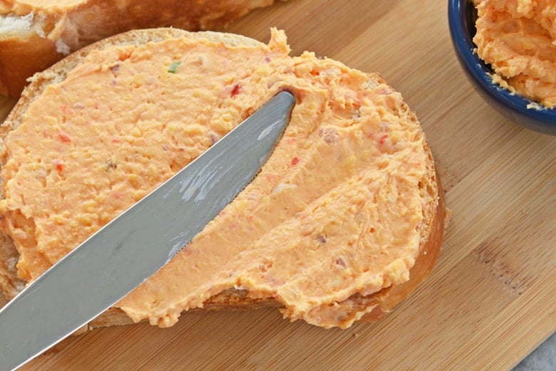 pimento cheese spreading onto a piece of bread 