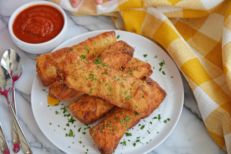 serving plate of pizza logs with side of dipping sauce 