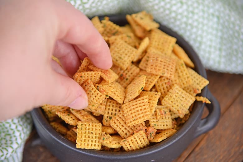 hand reaching into a bowl for chex mix 
