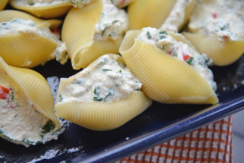 cooked stuffed shells stuffed with ricotta, spinach and roasted red pepper