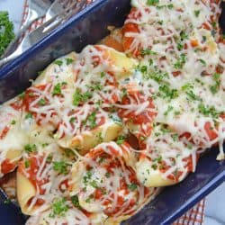 spinach stuffed shells in a blue casserole dish