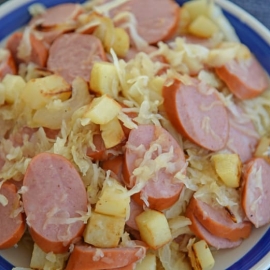 sauerkraut and sausage on a blue and white serving platter