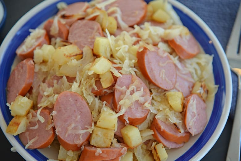 sauerkraut and sausage on a blue and white serving platter