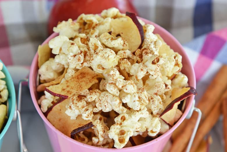 apple cinnamon popcorn in a pink bucket for serving 