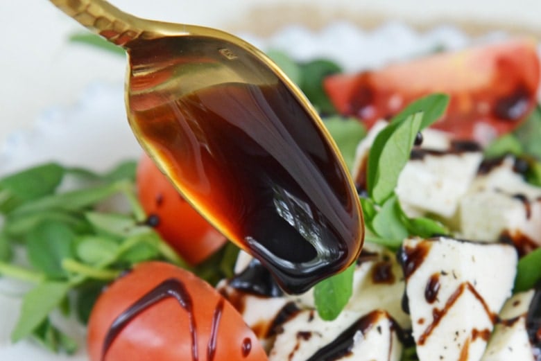 balsamic reduction drizzling onto a caprese salad