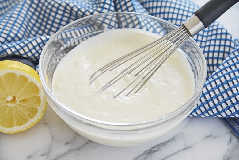 blue cheese dressing in a glass mixing bowl with whisk 