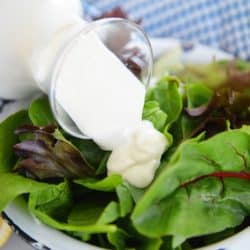 blue cheese dressing pouring over greens