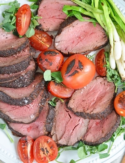 plate of seared beef tenderloin with tomatoes and scallions