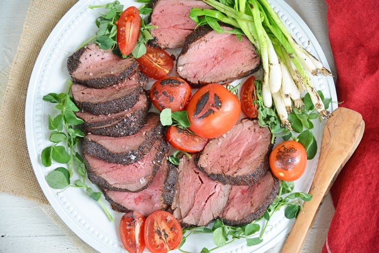 plate of seared beef tenderloin with tomatoes and scallions