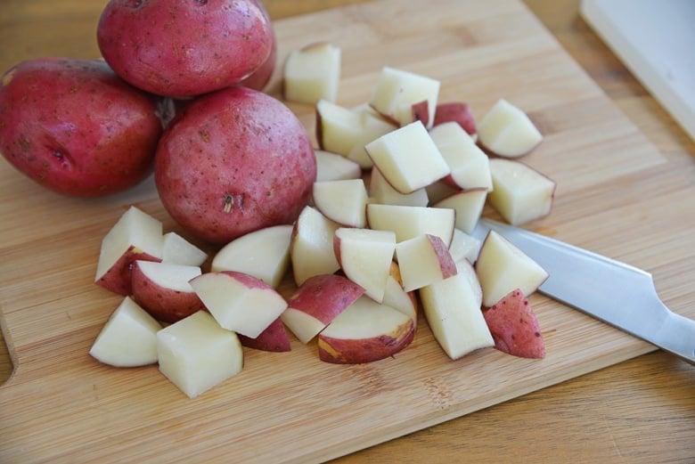 red potatoes on a wood chopping board  