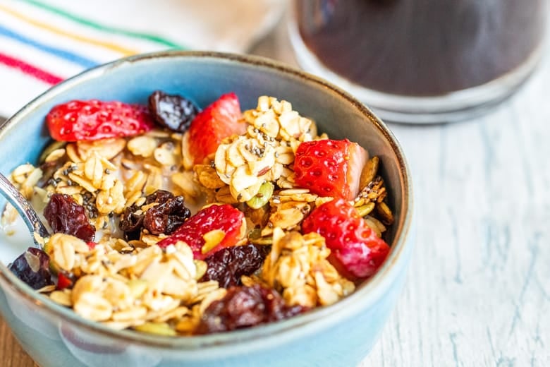 granola in a blue bowl with fresh berries 