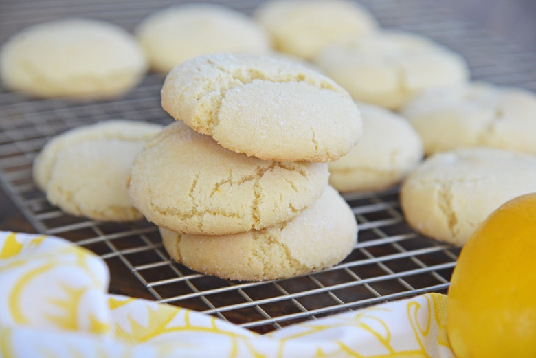lemon cookies in a pile on a cooling rack