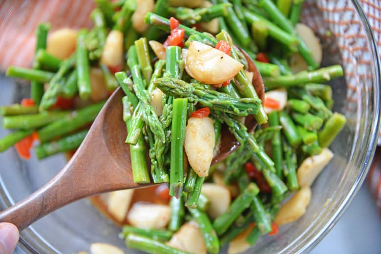 pickled asparagus salad in a wood serving spoon 