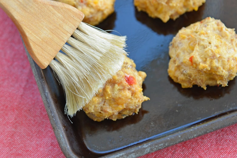 butter basting onto a cooked sausage ball 