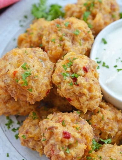 white plate with pimento cheese sausage balls with dipping sauce