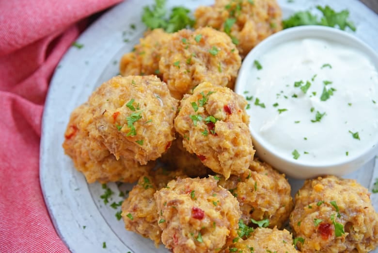 white plate with pimento cheese sausage balls with dipping sauce