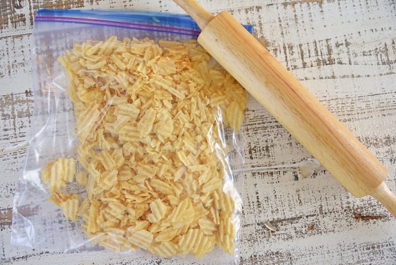 wavy potato chips in a plastic bag with a rolling pin 