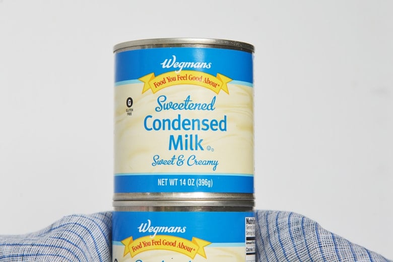 straight on shot of stack of cans of sweetened condensed milk