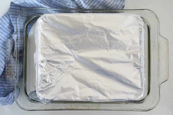 overhead shot of sweetened condensed milk in pan in water bath