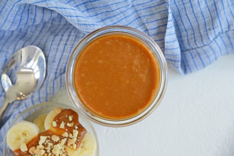 overhead view of homemade sweetened condensed milk caramel in a glass jar  