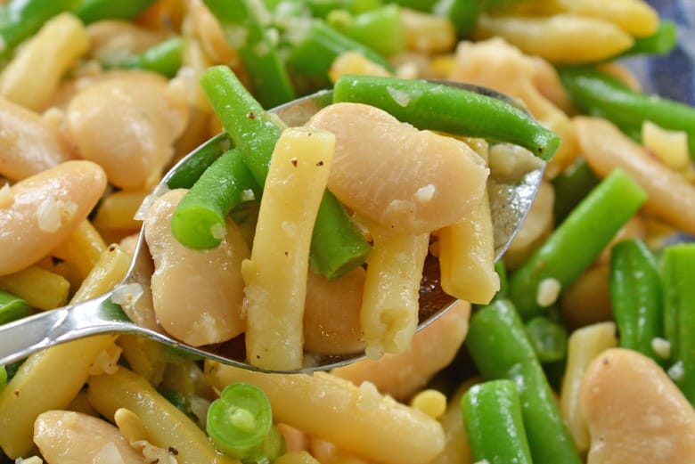 spoon holding marinated bean salad 