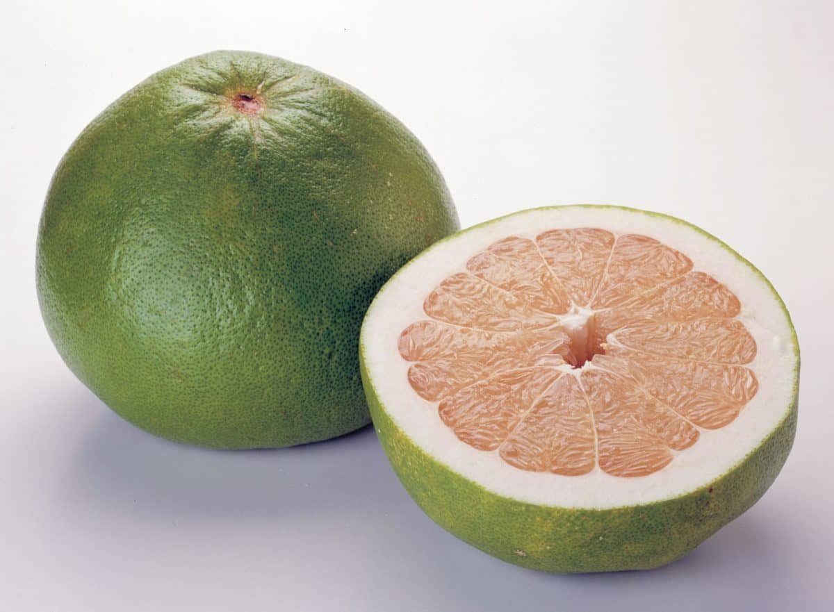 Pomelo cut in half on a cutting board