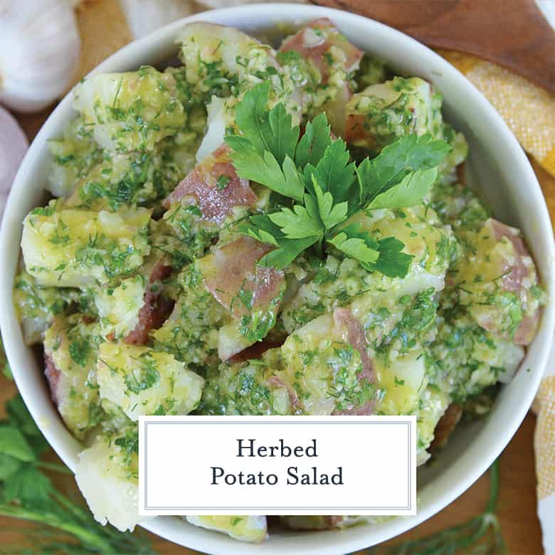 Overhead view of cold potato salad in a white bowl garnished with parsley 