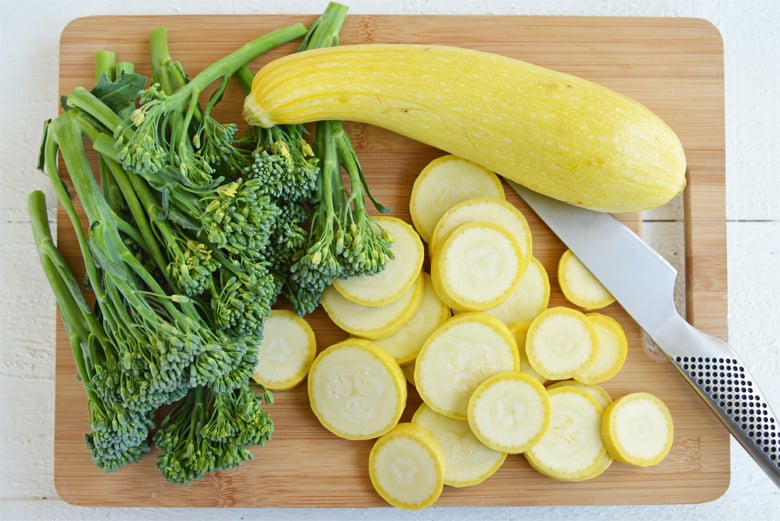 summer squash and broccolini on a cutting board 