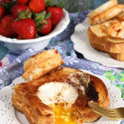 angled shot of egg in a hole grilled cheese on a plate