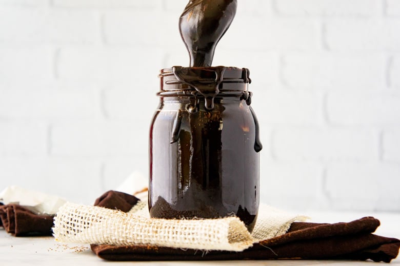 jar of fudge sauce with a spoon dipping in