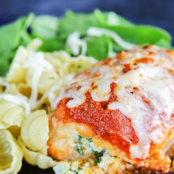 spinach stuffed chicken on a black plate