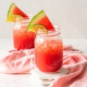 vodka watermelon cocktails in mason jars with fresh watermelon wedge garnish