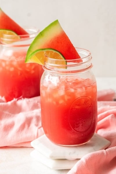 vodka watermelon cocktails in mason jars with fresh watermelon wedge garnish