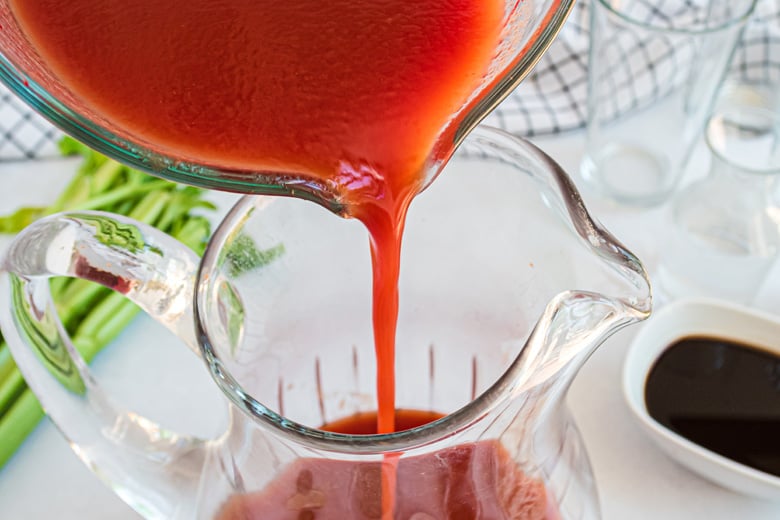 tomato juice pouring into a pitcher 