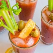 overhead of bloody mary with celery, lemon and olive garnish